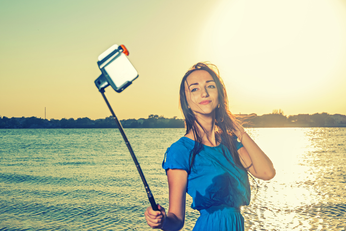 Young women make selfie with selfie-stick toned instagram style